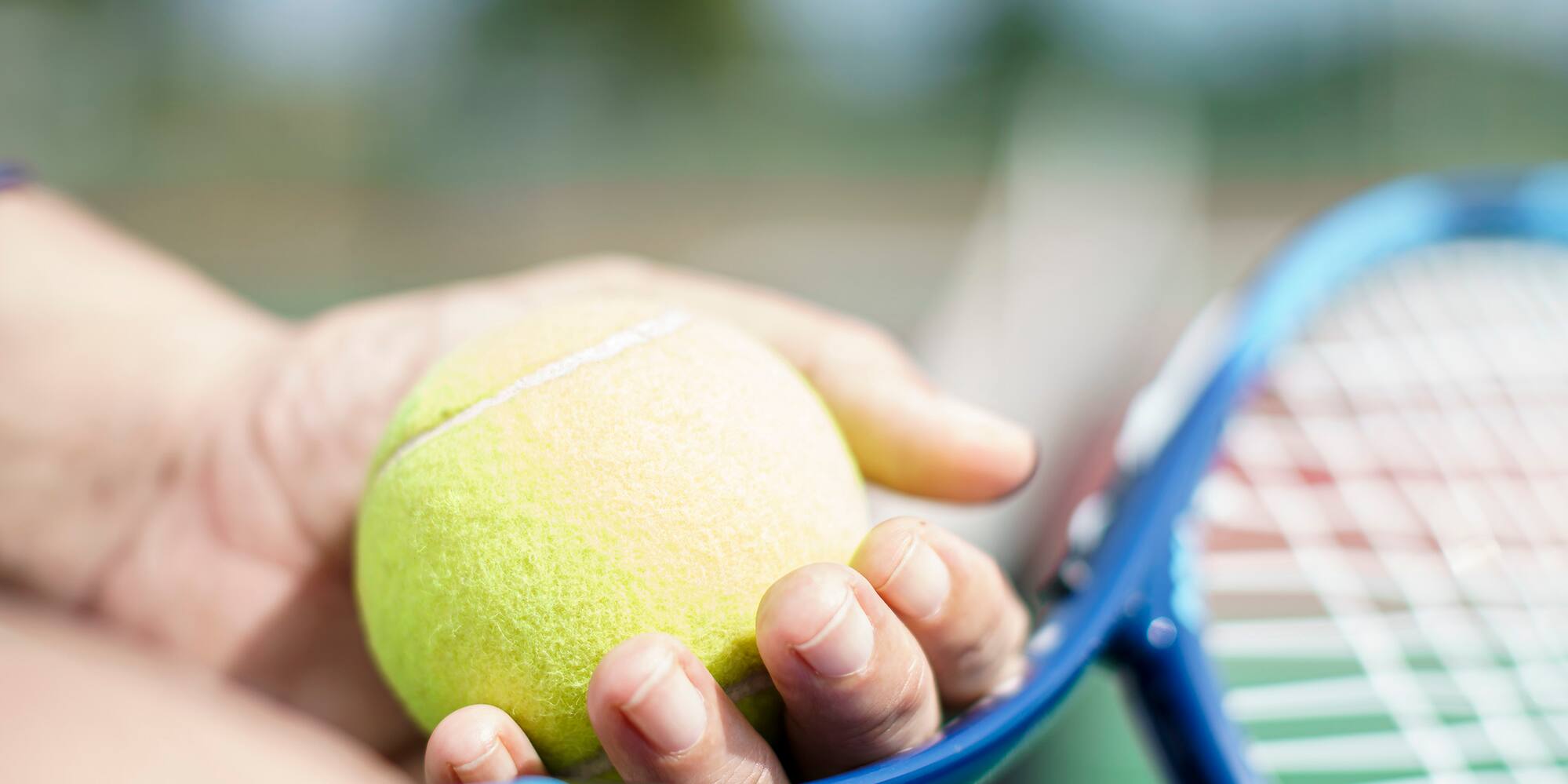 a person holding a tennis racket and a ball