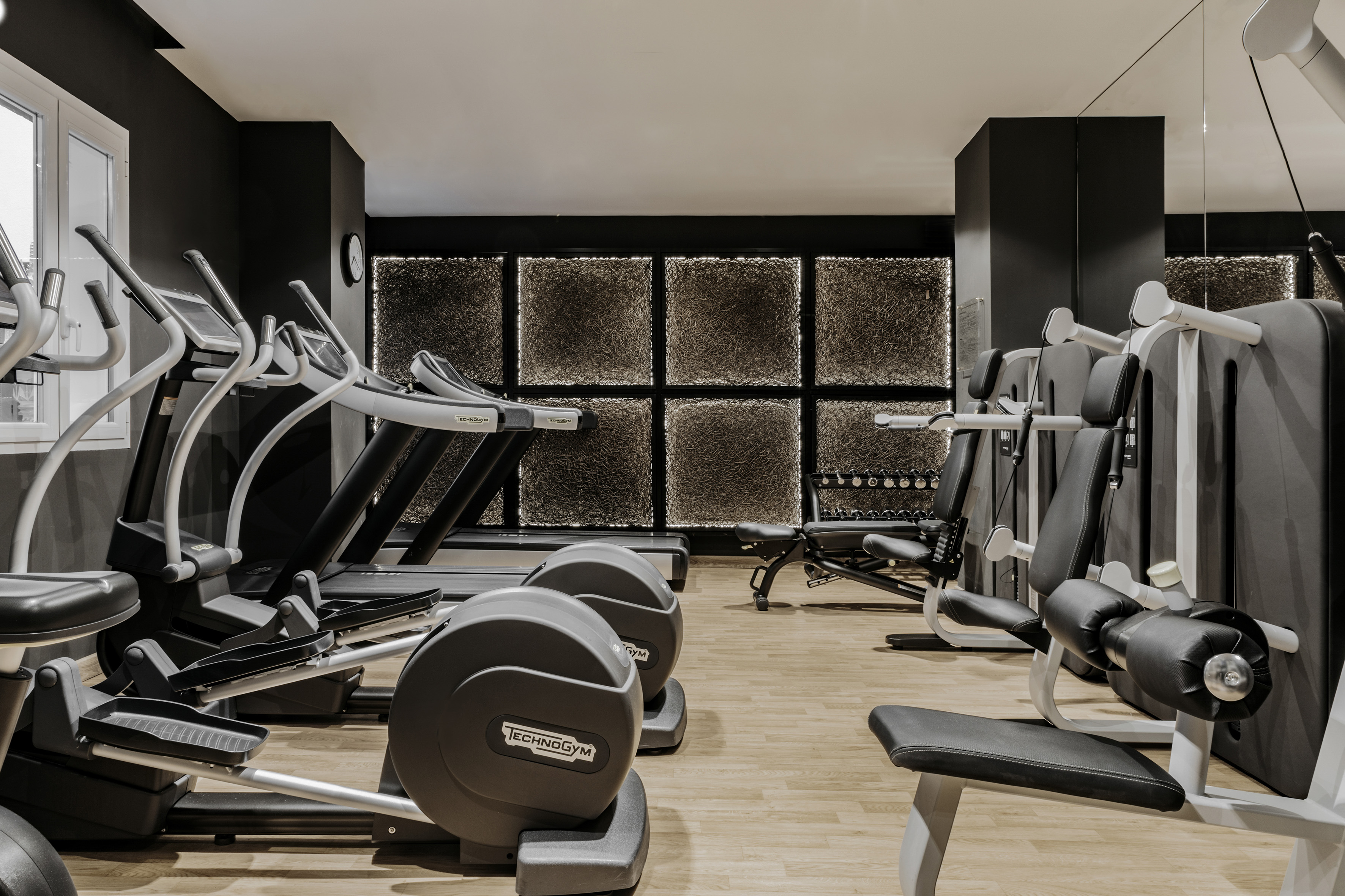 Stylish hotel gym with Technogym cardio and strength training equipment.
