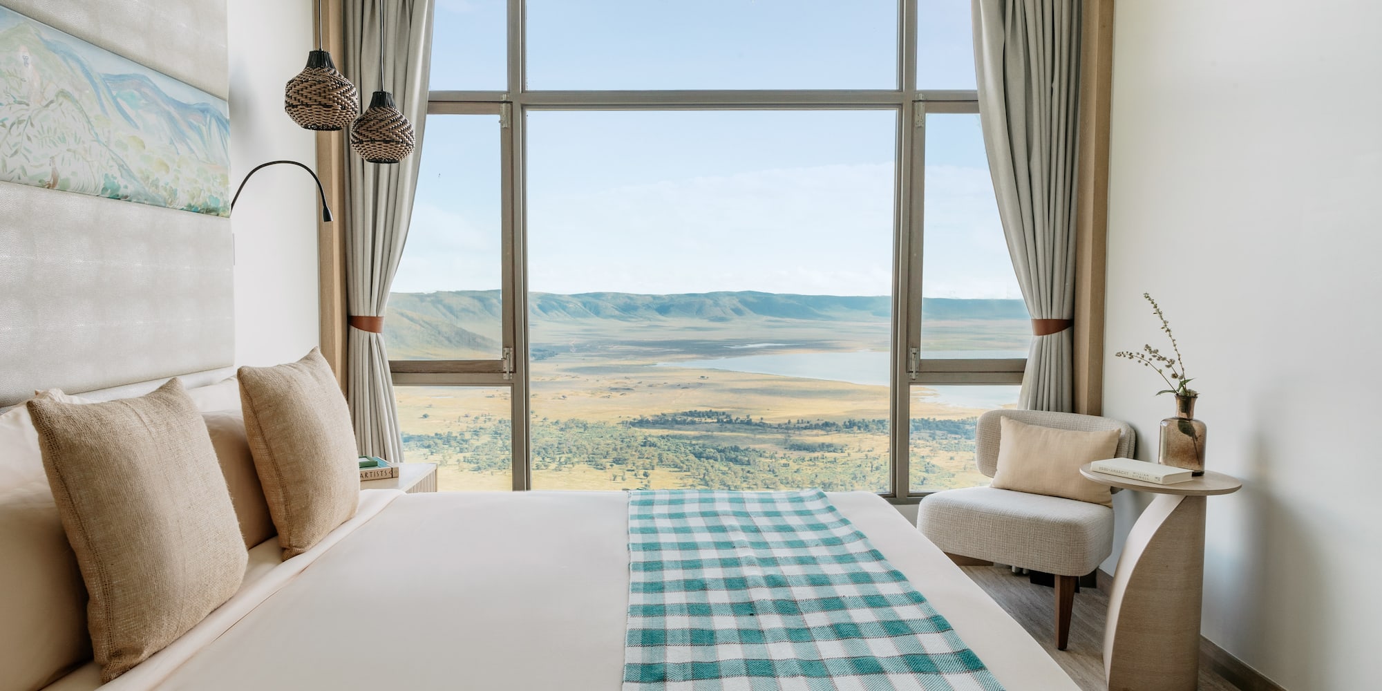 a room with a bed and chairs and a view of the valley