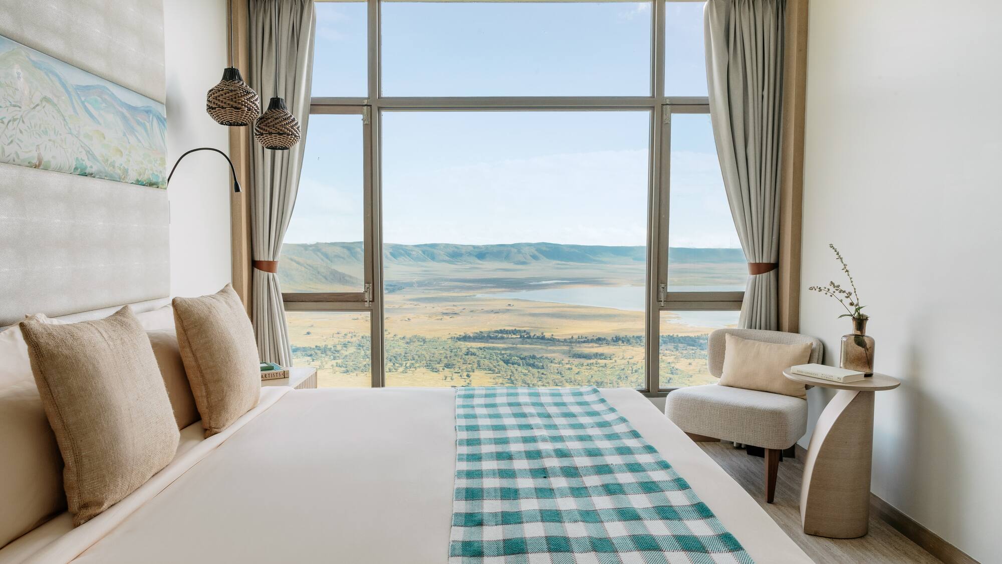 a room with a bed and chairs and a view of the valley