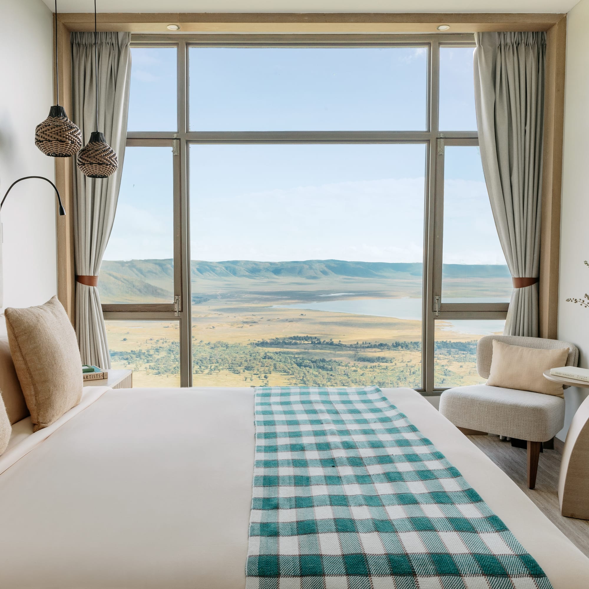 a room with a bed and chairs and a view of the valley