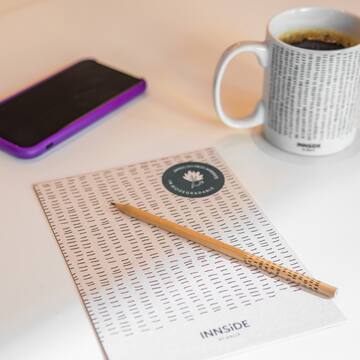 a pencil on a paper next to a cup of coffee