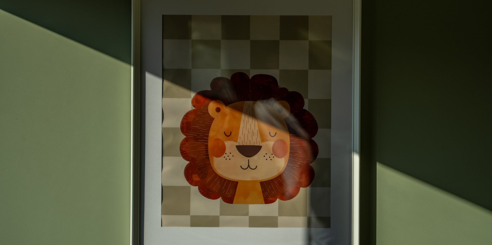 Framed cartoon lion print on green wall, sunlight and diagonal shadow.