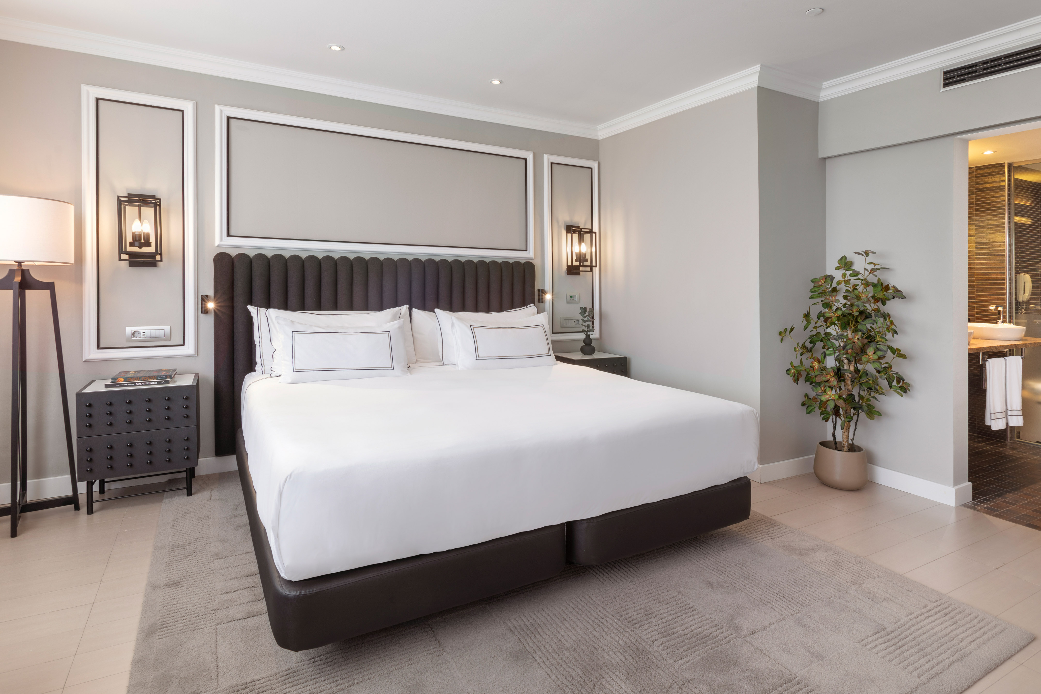 Modern hotel bedroom with king bed, contemporary design, and ensuite bathroom.