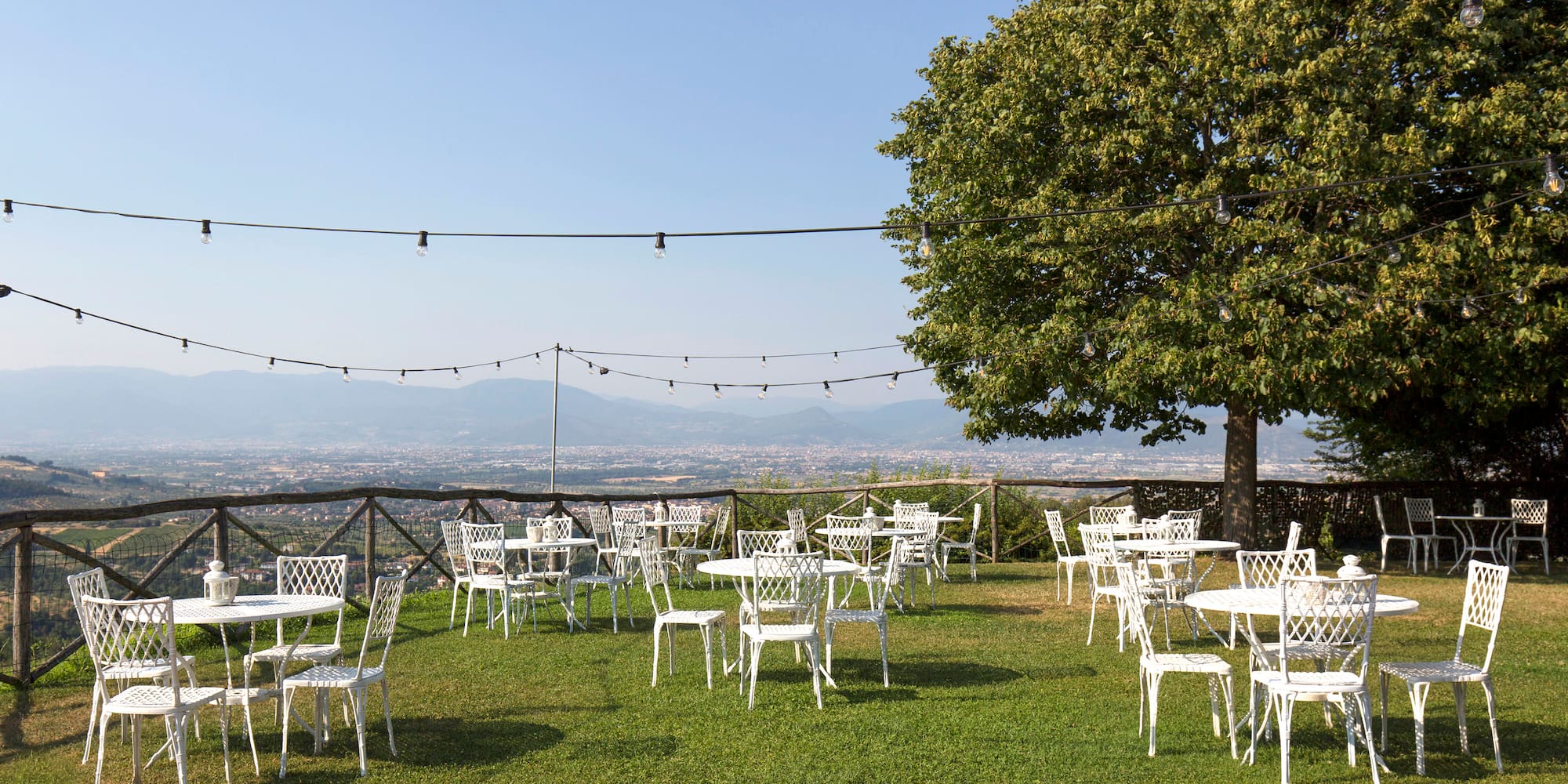 a group of white chairs and tables on a grassy area