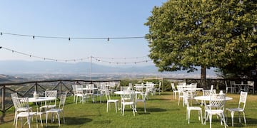 a group of white chairs and tables on a grassy area