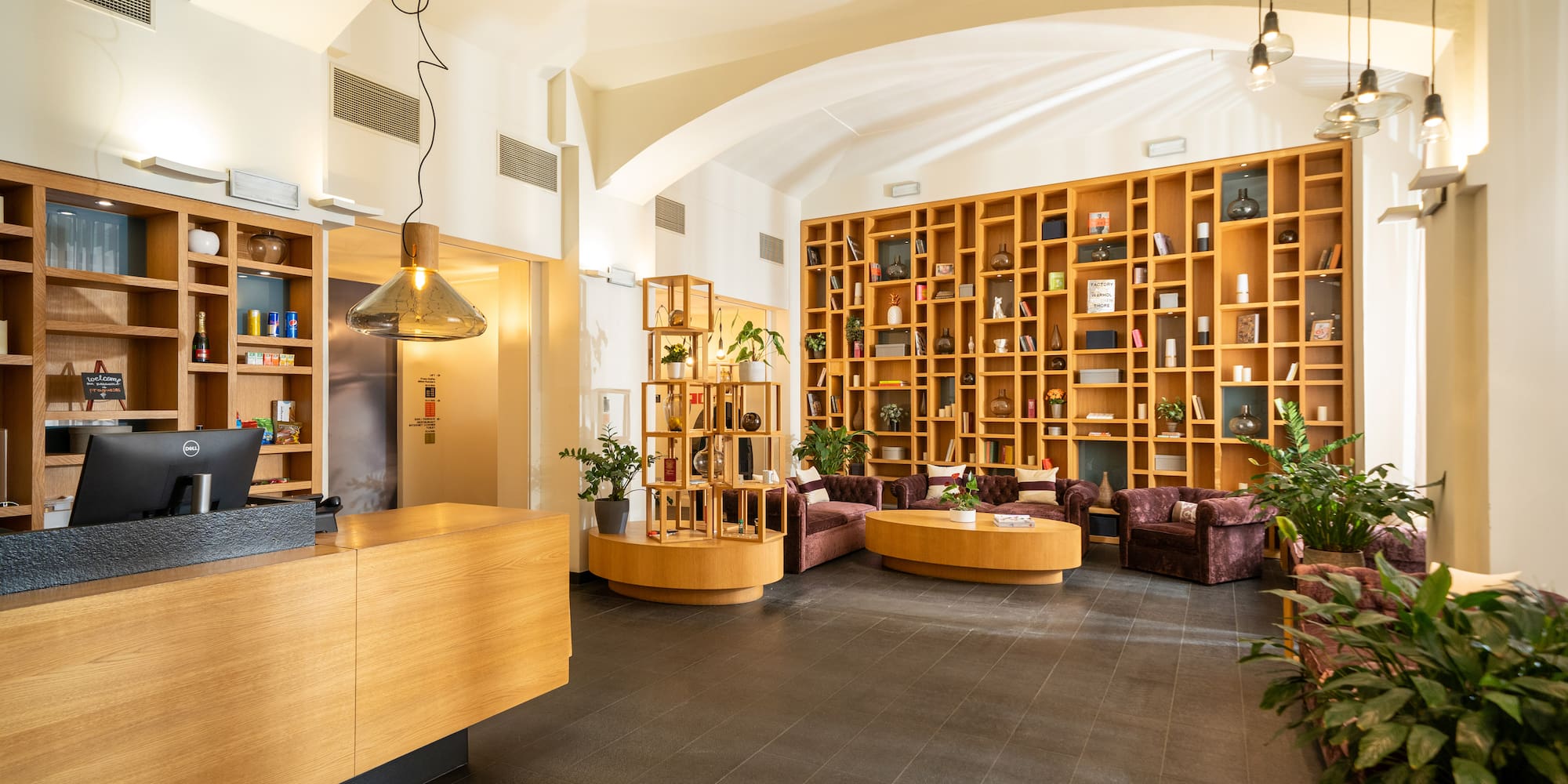 a room with a reception desk and shelves of books