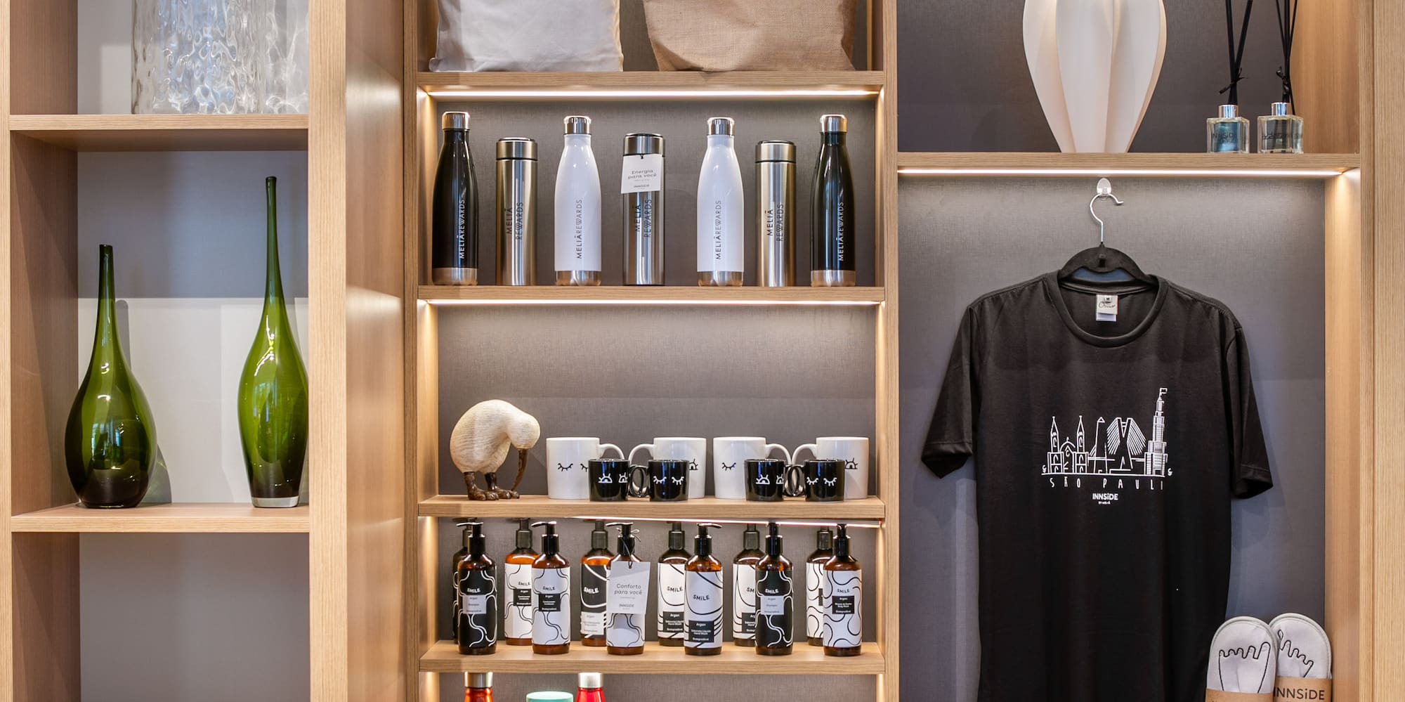 Wooden hotel display with Meliá Rewards & Innside merchandise.