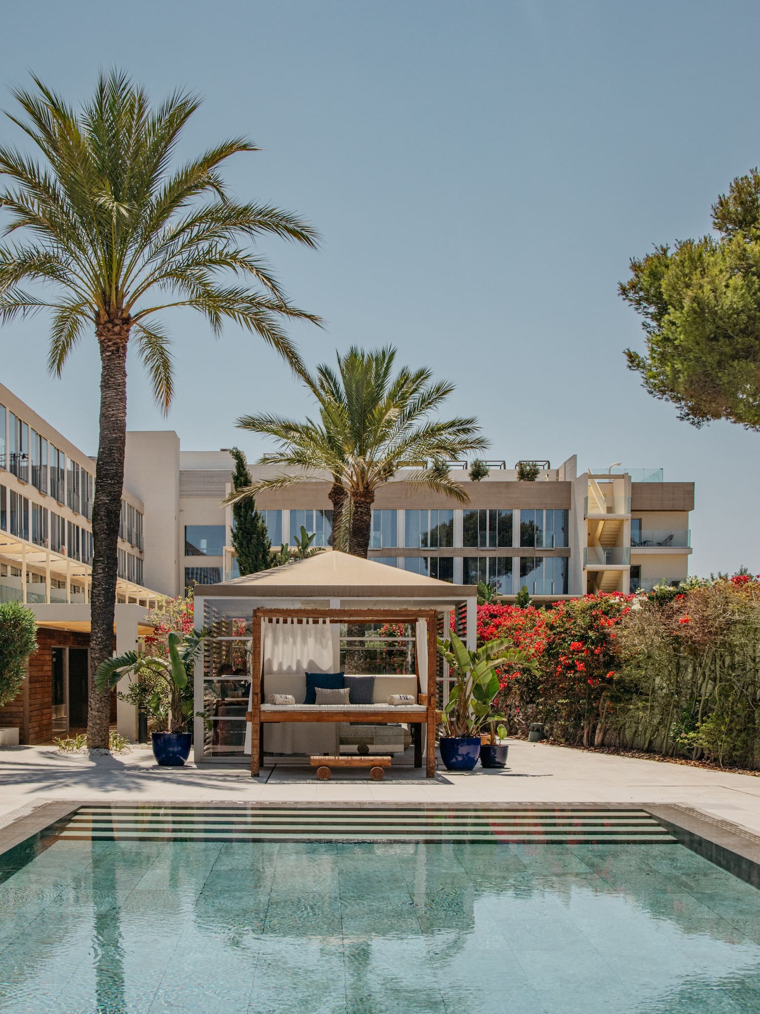 a pool with a gazebo and palm trees
