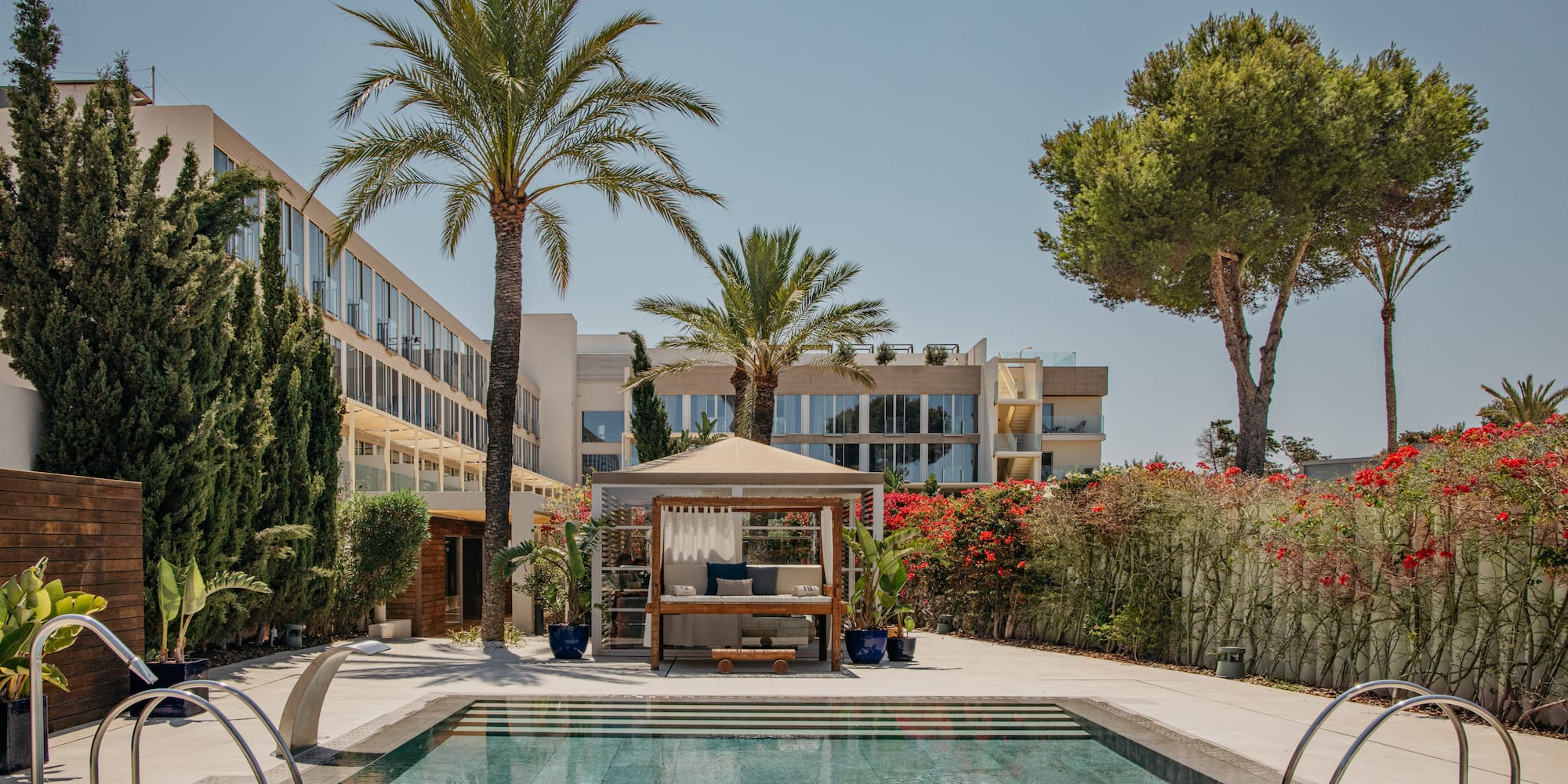 a pool with a gazebo and palm trees.