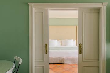 a door with a bed and a chair in the background