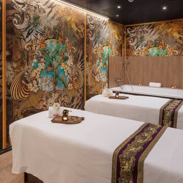 a room with two beds and a wall with art on the wall