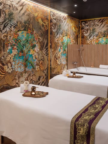 a room with two beds and a wall with art on the wall