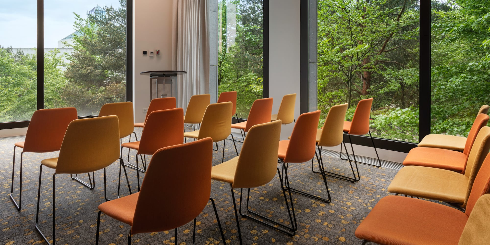 a room with many chairs and trees outside