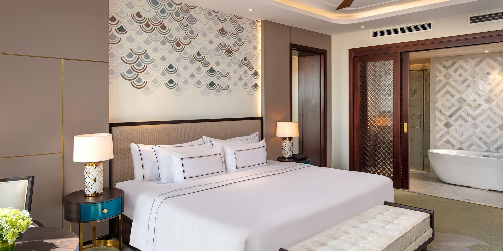 a bed with a fan and a bench in a room