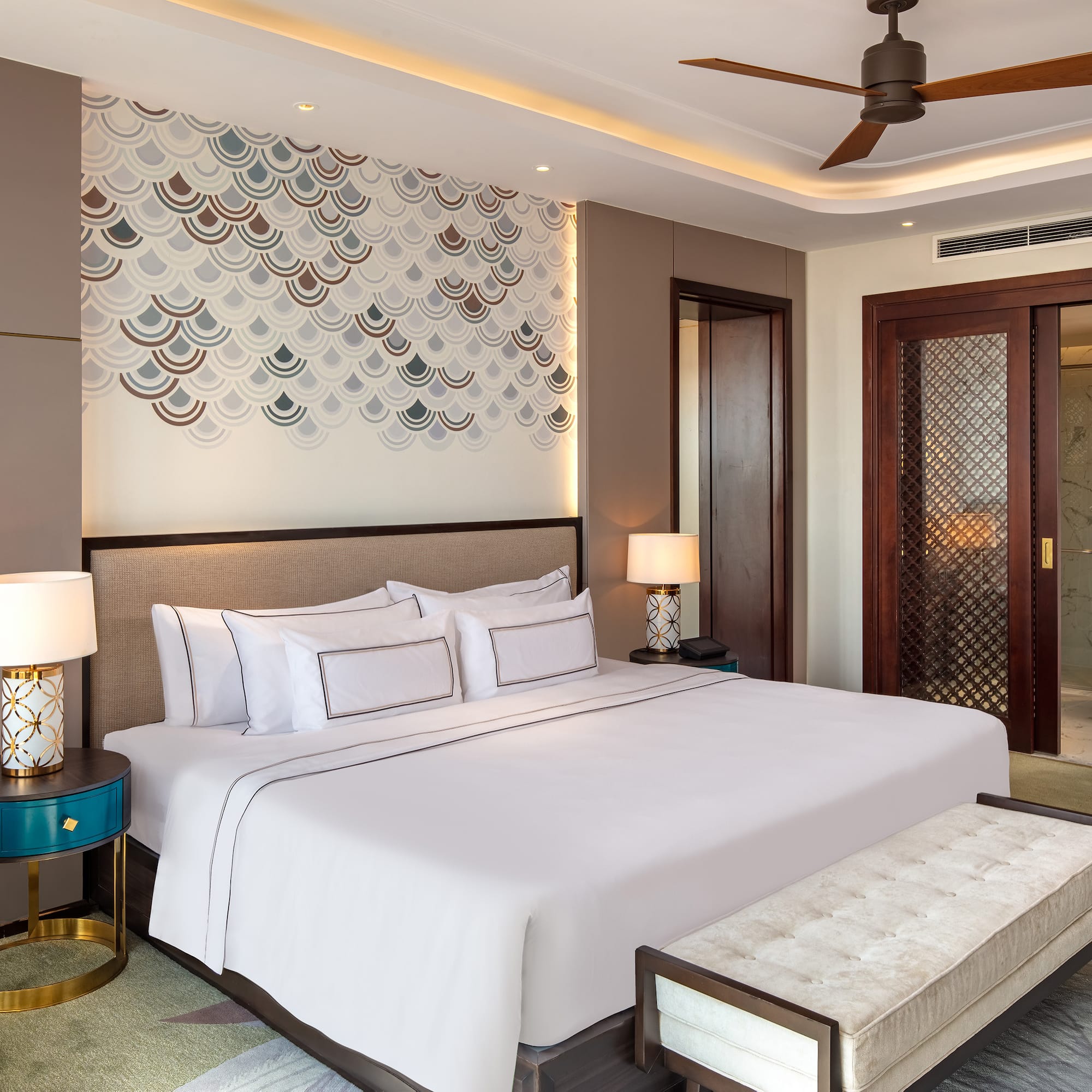 a bed with a fan and a bench in a room