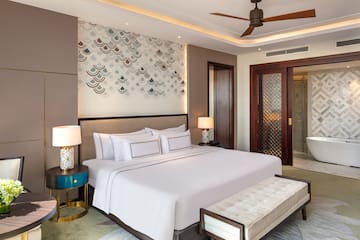 a bed with a fan and a bench in a room
