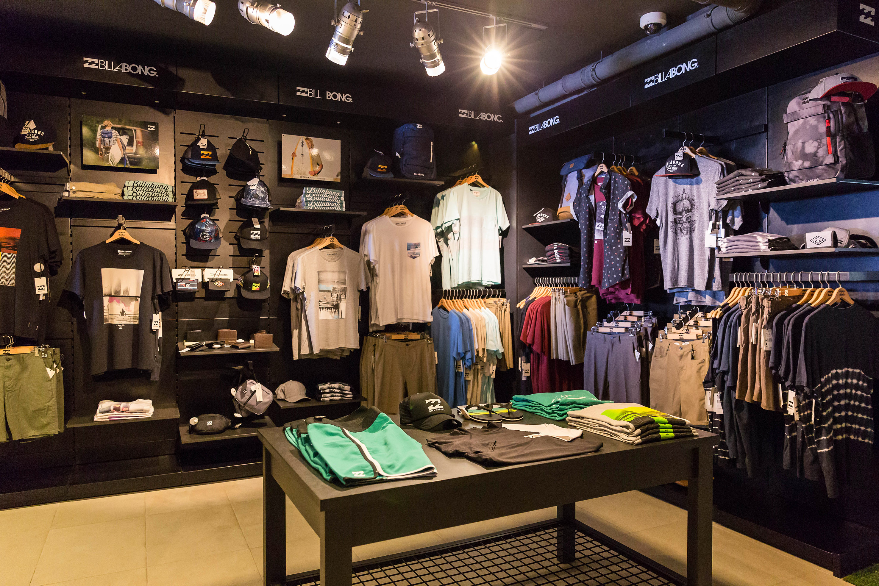 Billabong retail store display with men's surf apparel, t-shirts, shorts, hats.