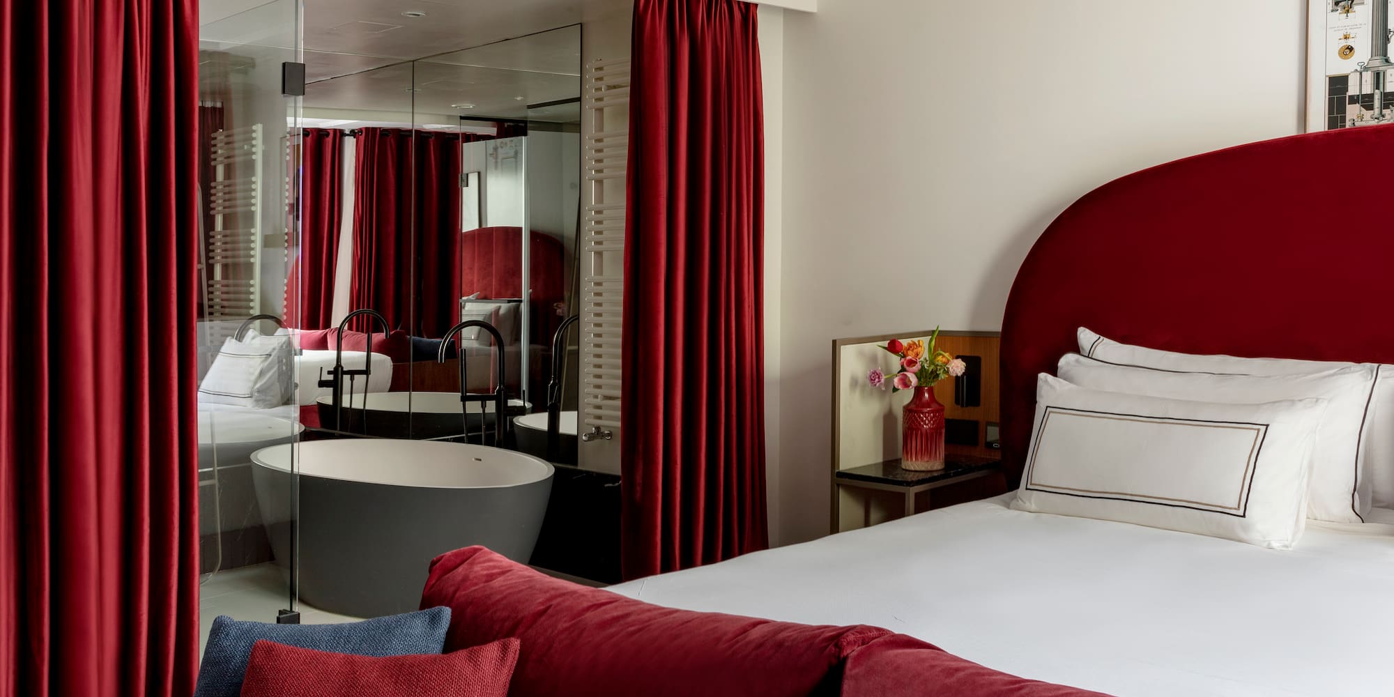 a bedroom with red curtains and a tub