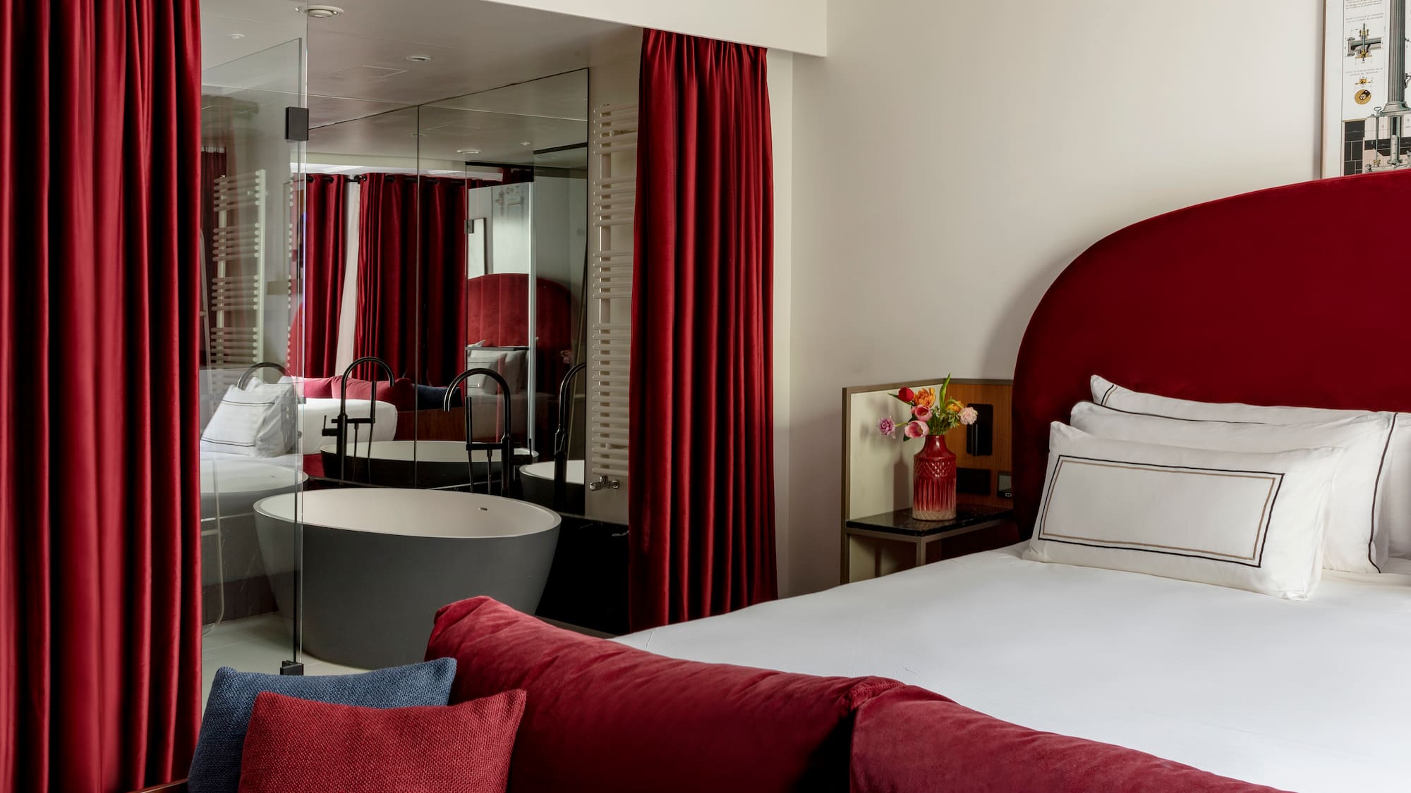 a bedroom with red curtains and a tub