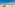Beachfront stone villas, lush gardens, turquoise sea, and palm trees.