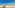 Beachfront stone villas, lush gardens, turquoise sea, and palm trees.
