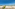 Beachfront stone villas, lush gardens, turquoise sea, and palm trees.