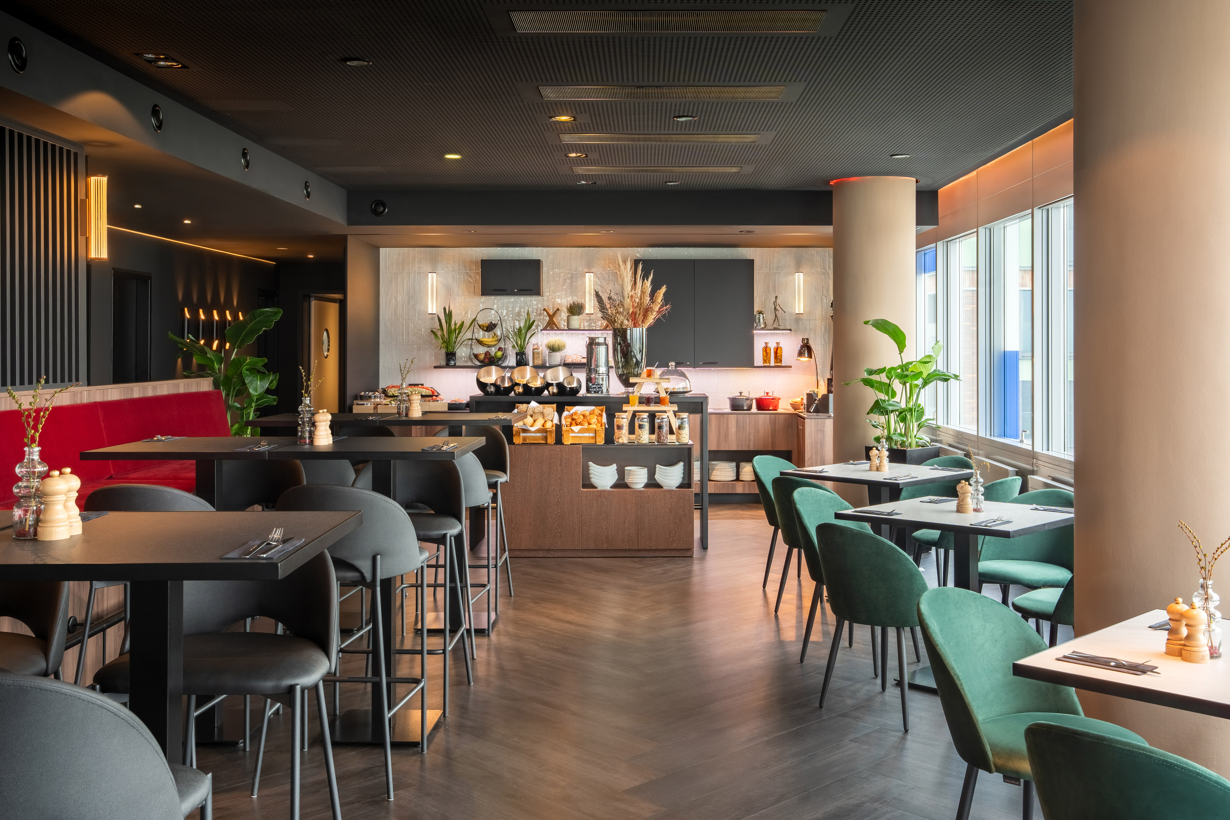 Modern hotel restaurant with breakfast buffet and stylish seating areas.