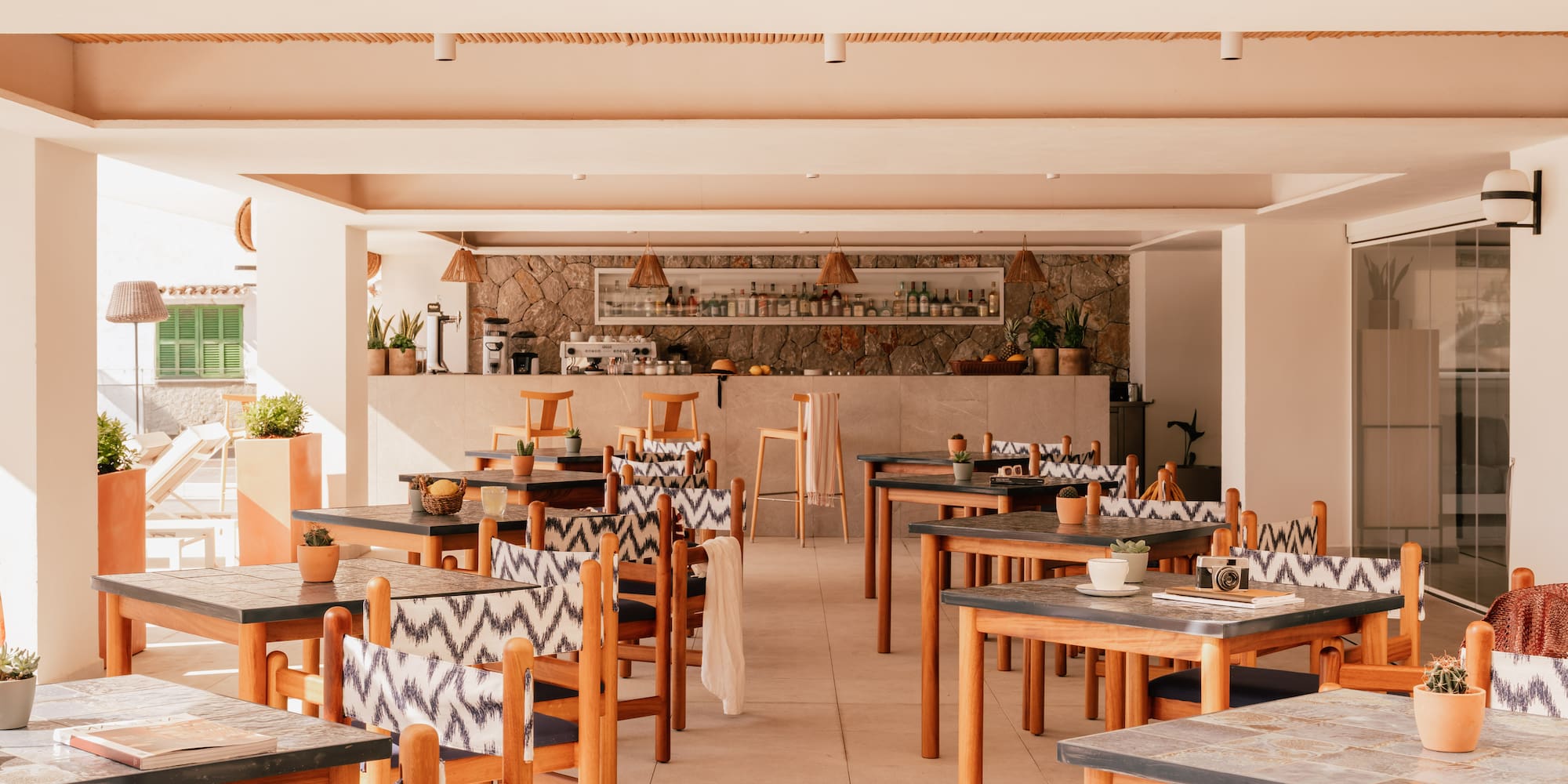 Bright resort restaurant and bar with wooden tables and patterned chairs.