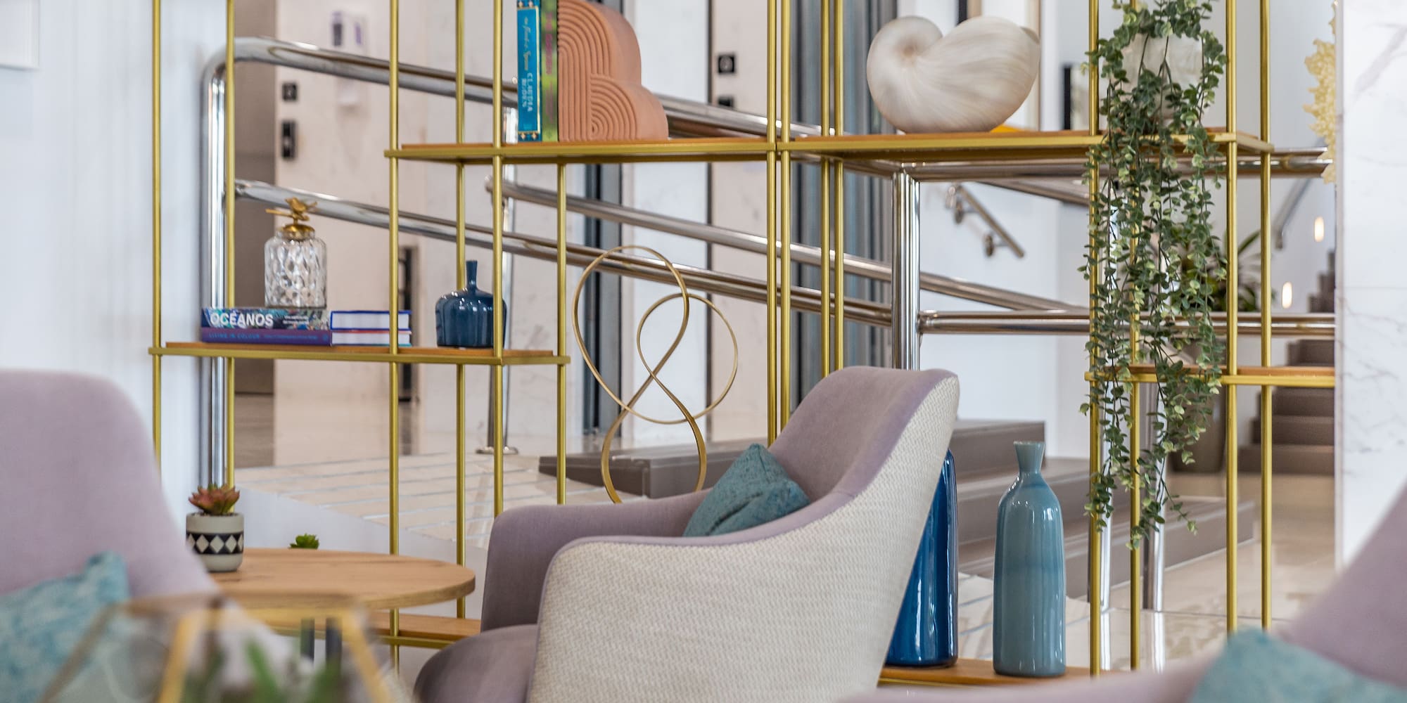 a room with a gold shelf and chairs