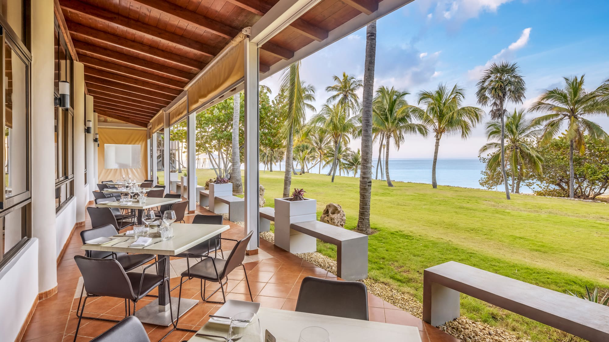 a restaurant with tables and chairs and grass and trees