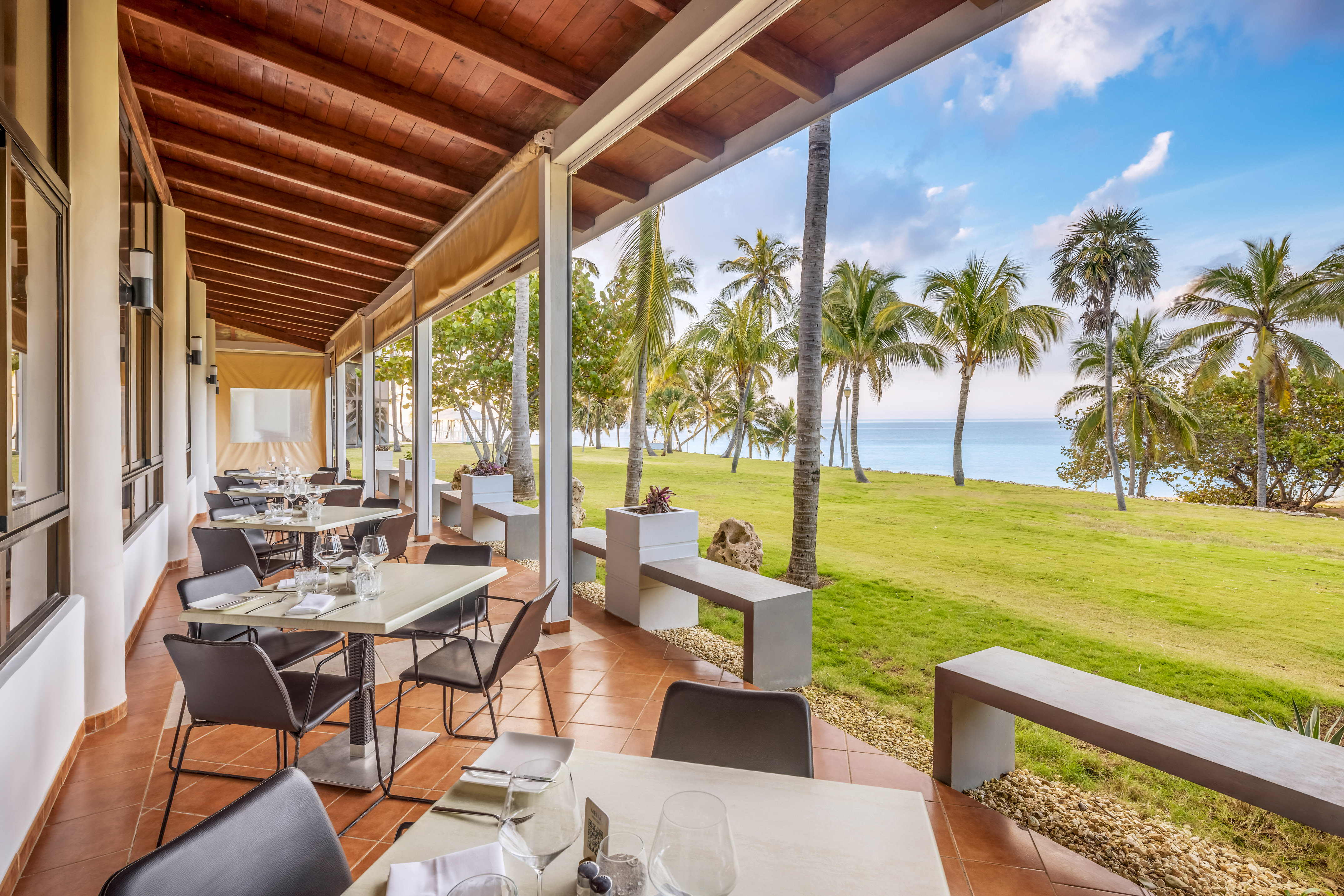 a restaurant with tables and chairs and grass and trees