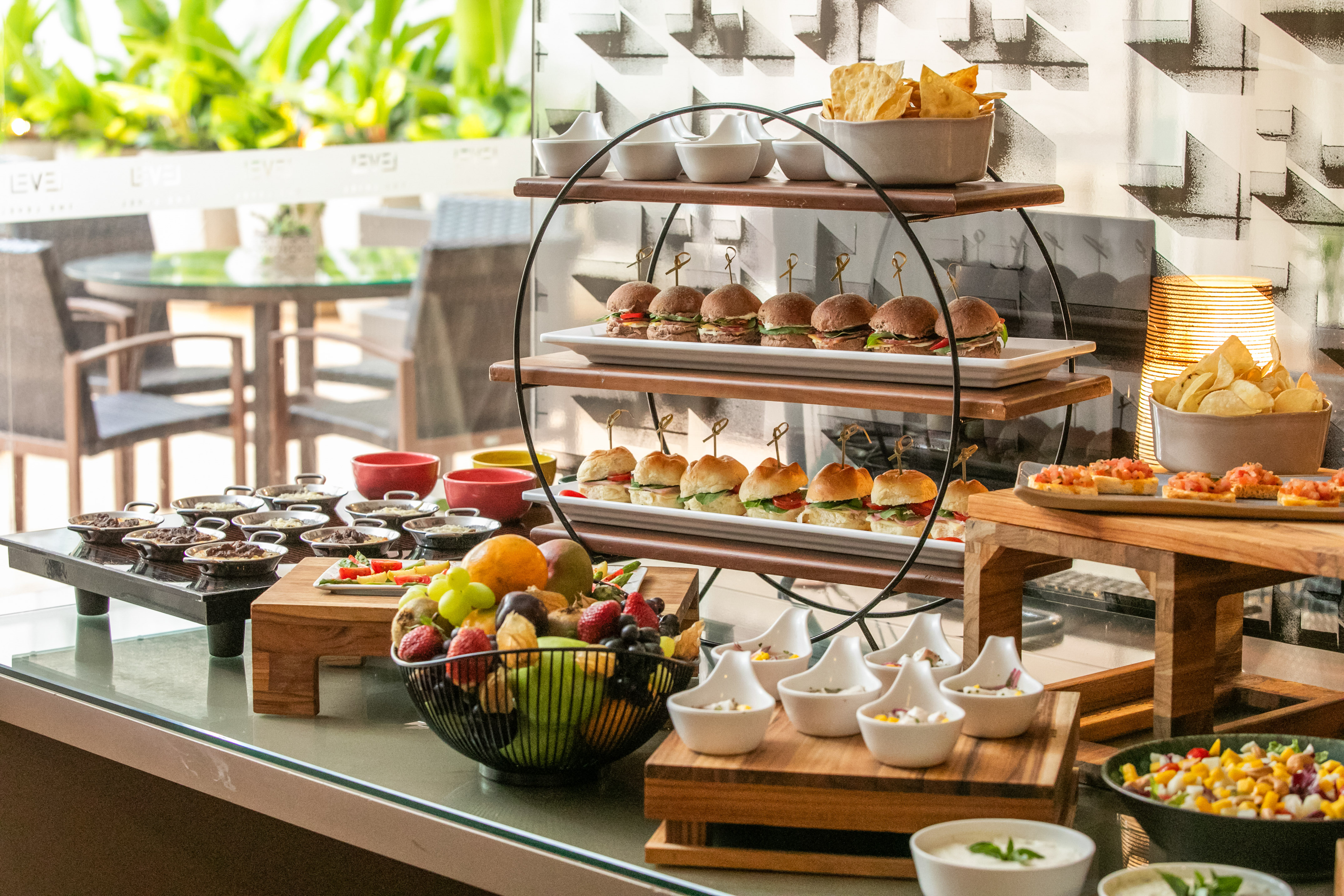Restaurant buffet with mini burgers, fresh fruit, chips, and appetizers.