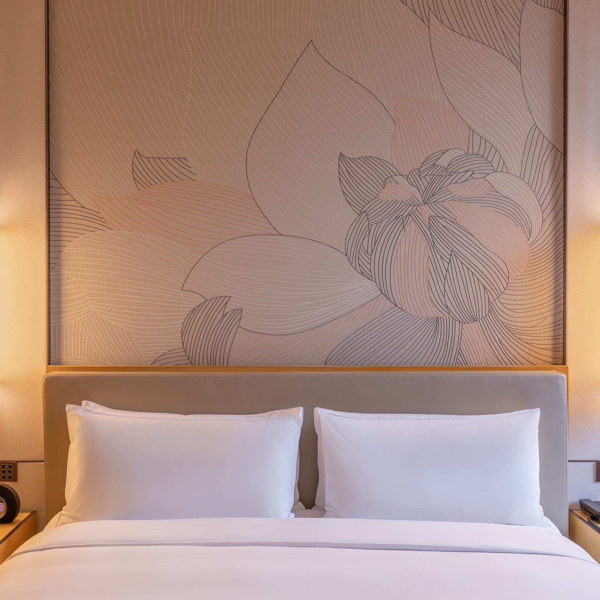 a bed with a wallpaper and lamps