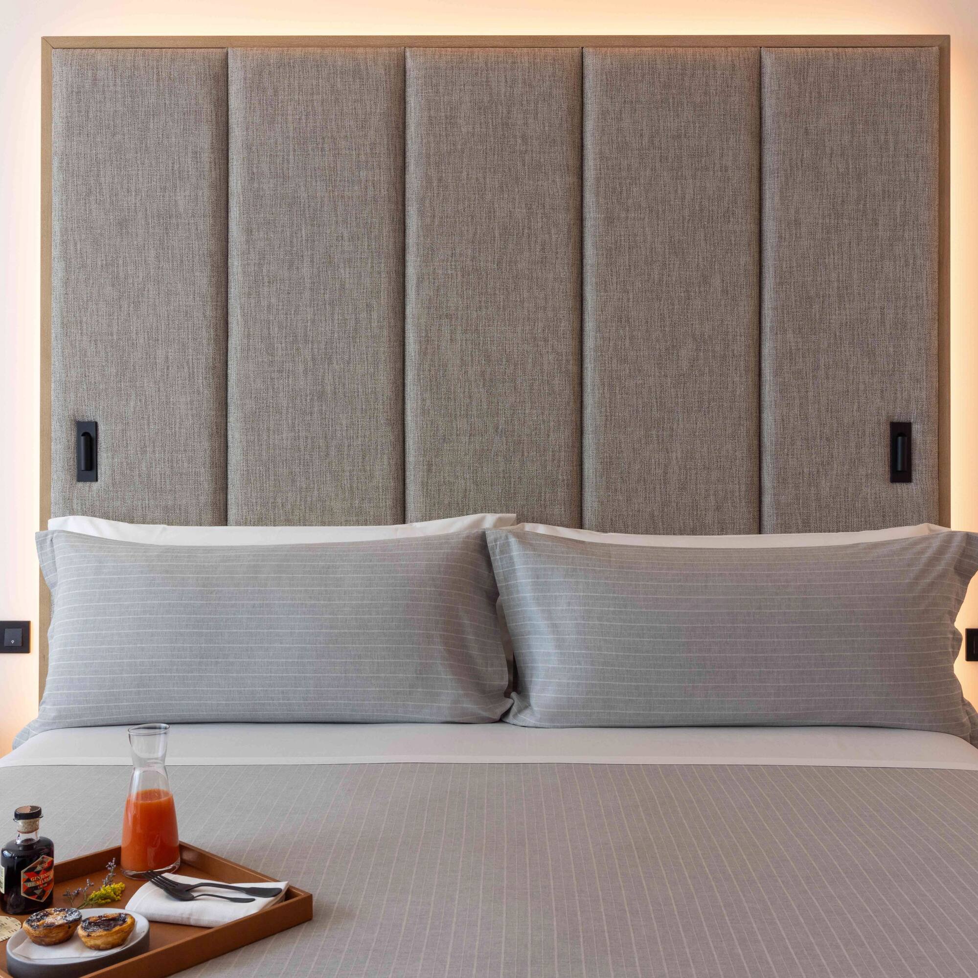 a bed with a tray of food and a drink on it