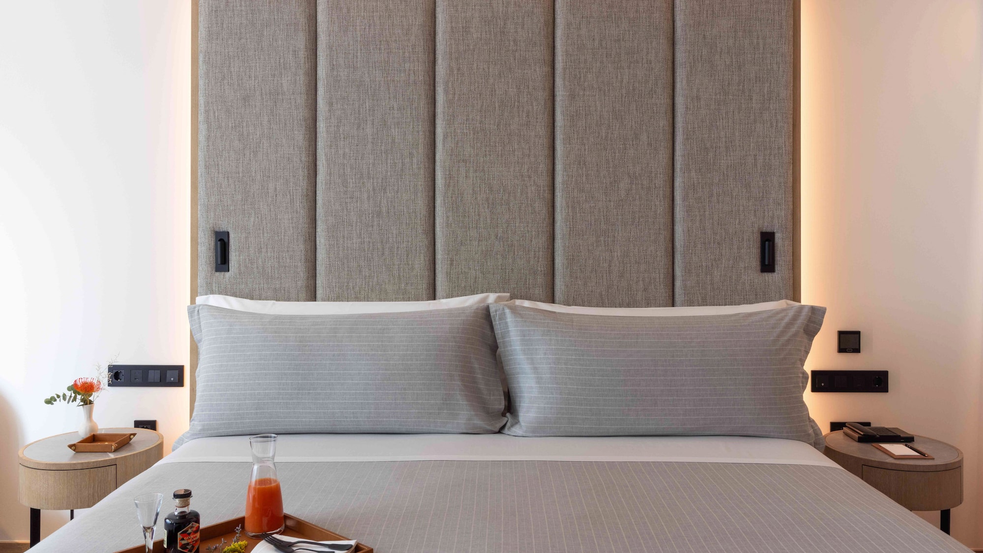 a bed with a tray of food and a drink on it