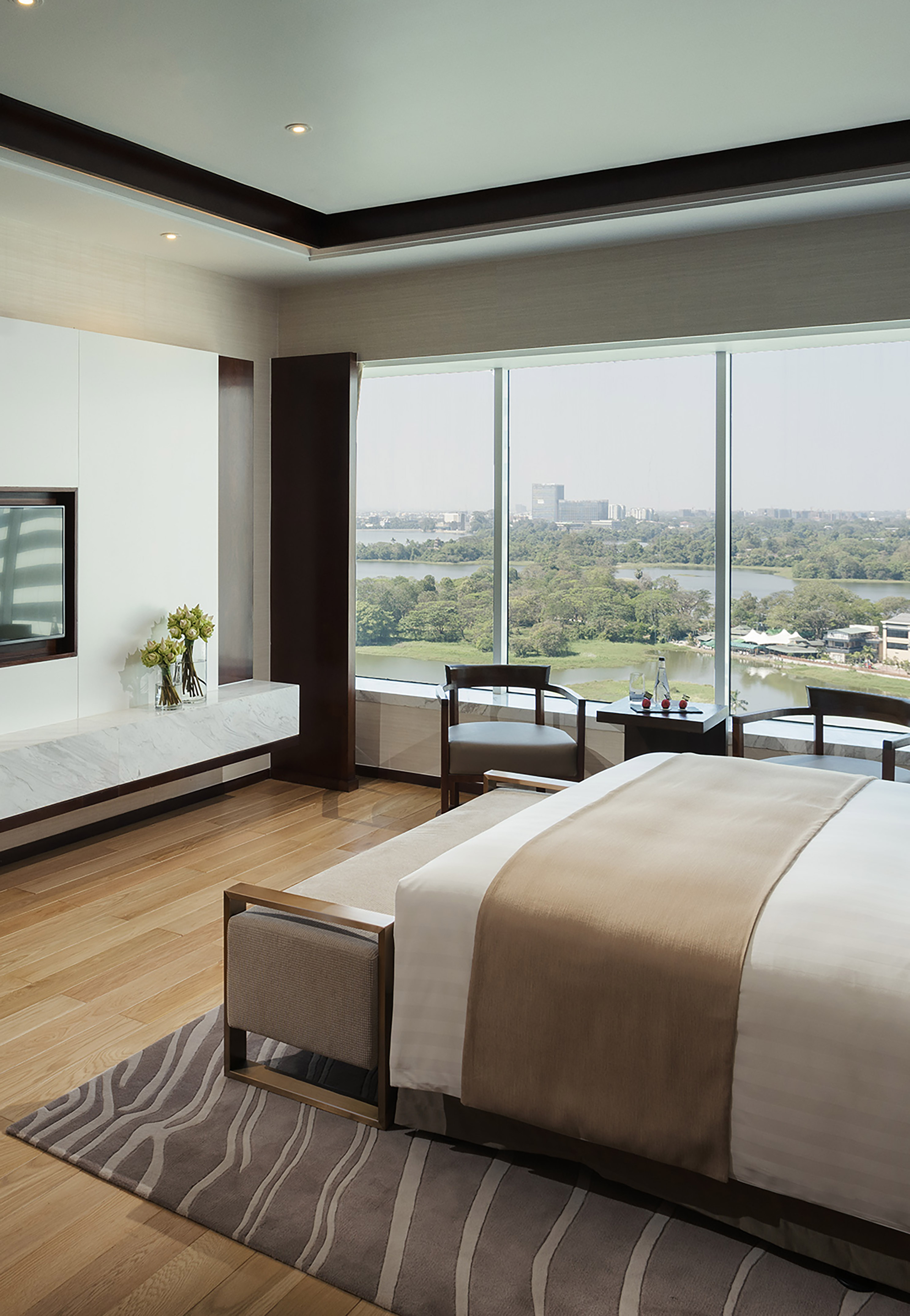 Luxury hotel suite with panoramic lake and city view, modern design.