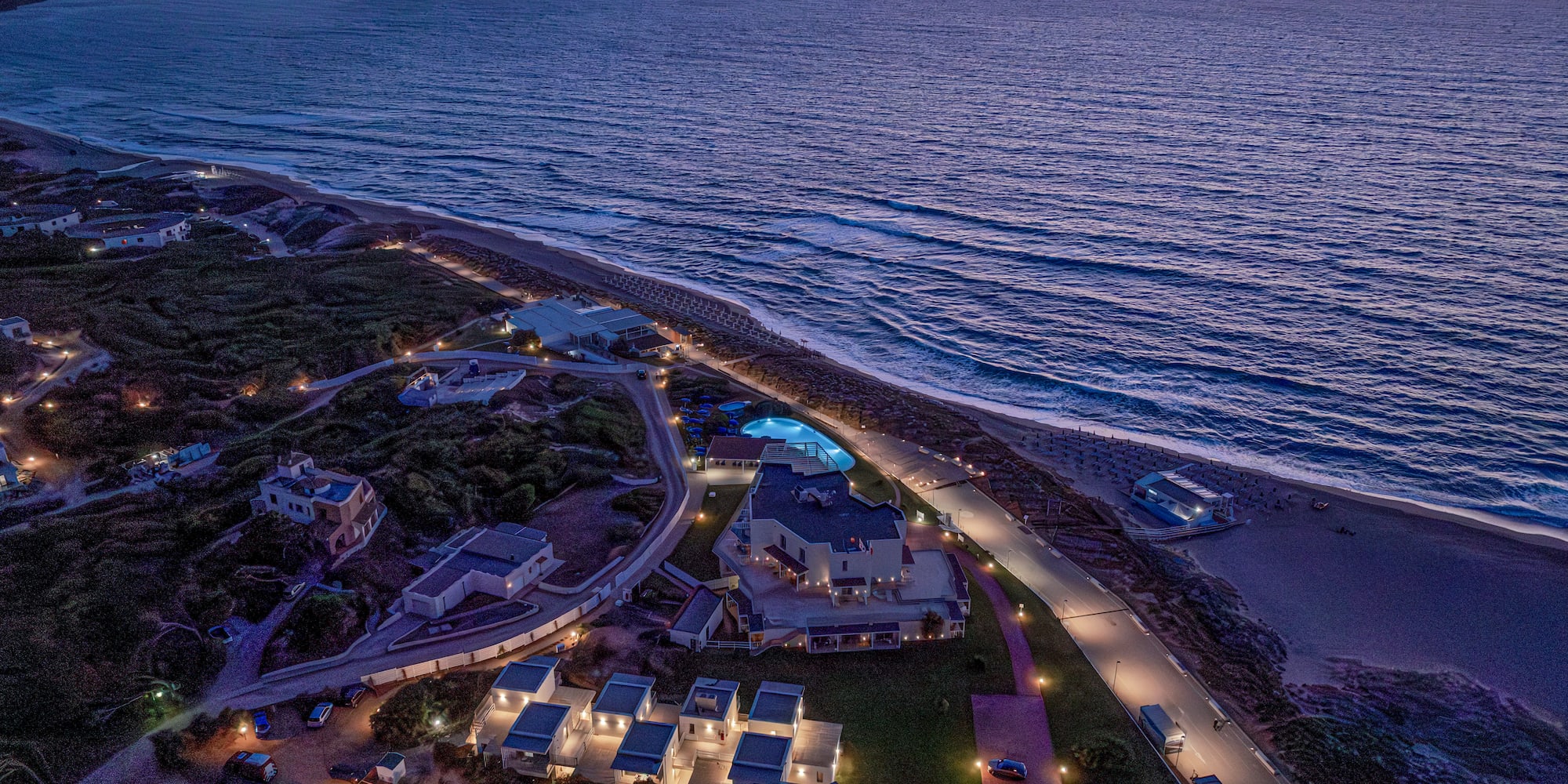 a aerial view of a beach with houses and a pool