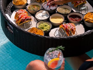 a person holding a drink and a bowl of food