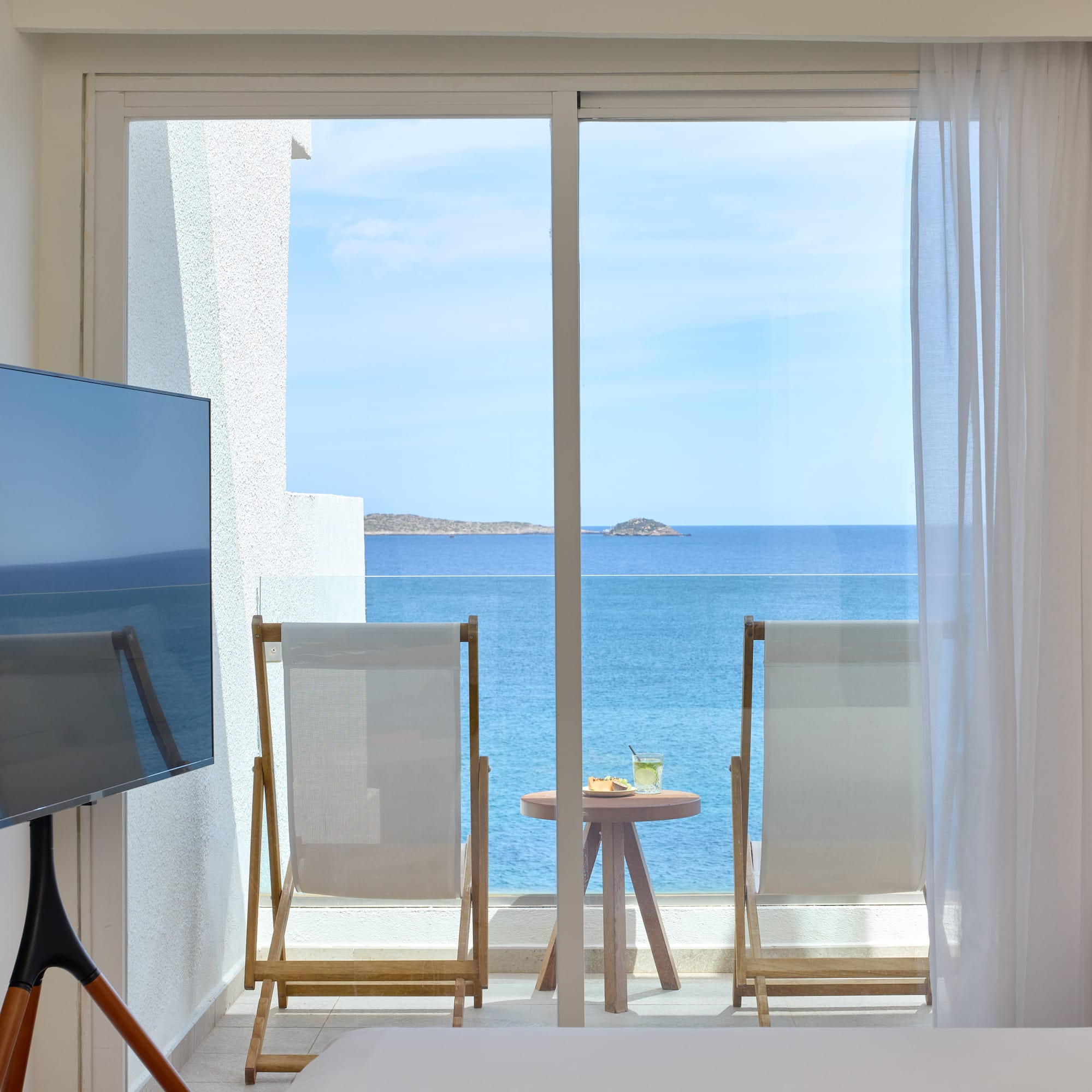 a room with a television and a view of the ocean