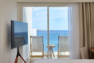a room with a television and a view of the ocean