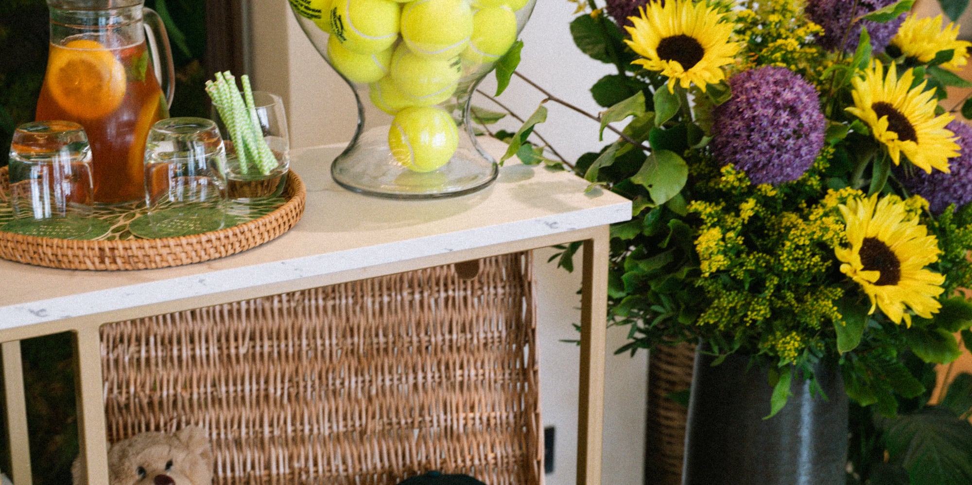 Wimbledon tennis decor: Balls, vintage racket, hat, sunflowers, iced tea.