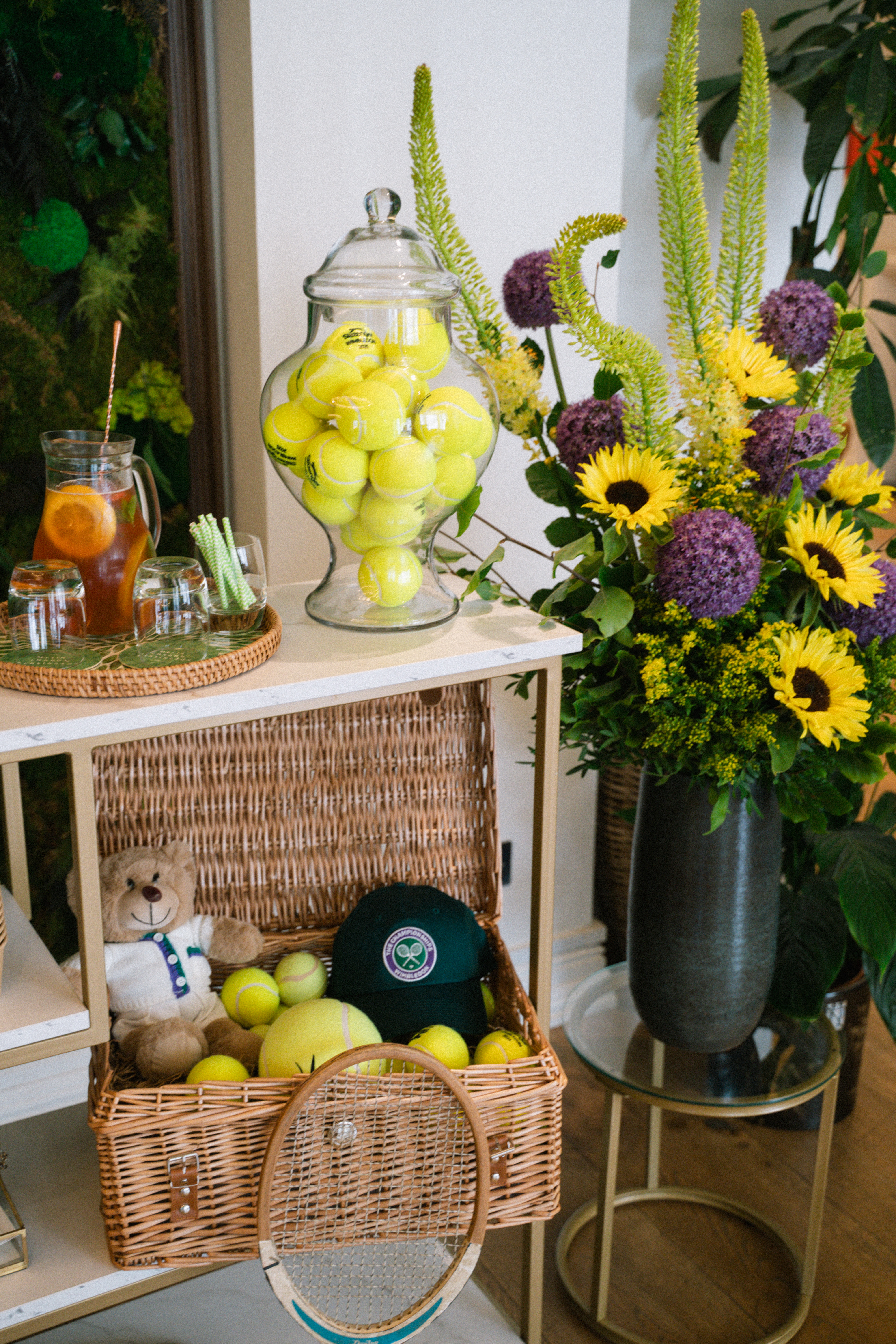 Wimbledon tennis decor: Balls, vintage racket, hat, sunflowers, iced tea.