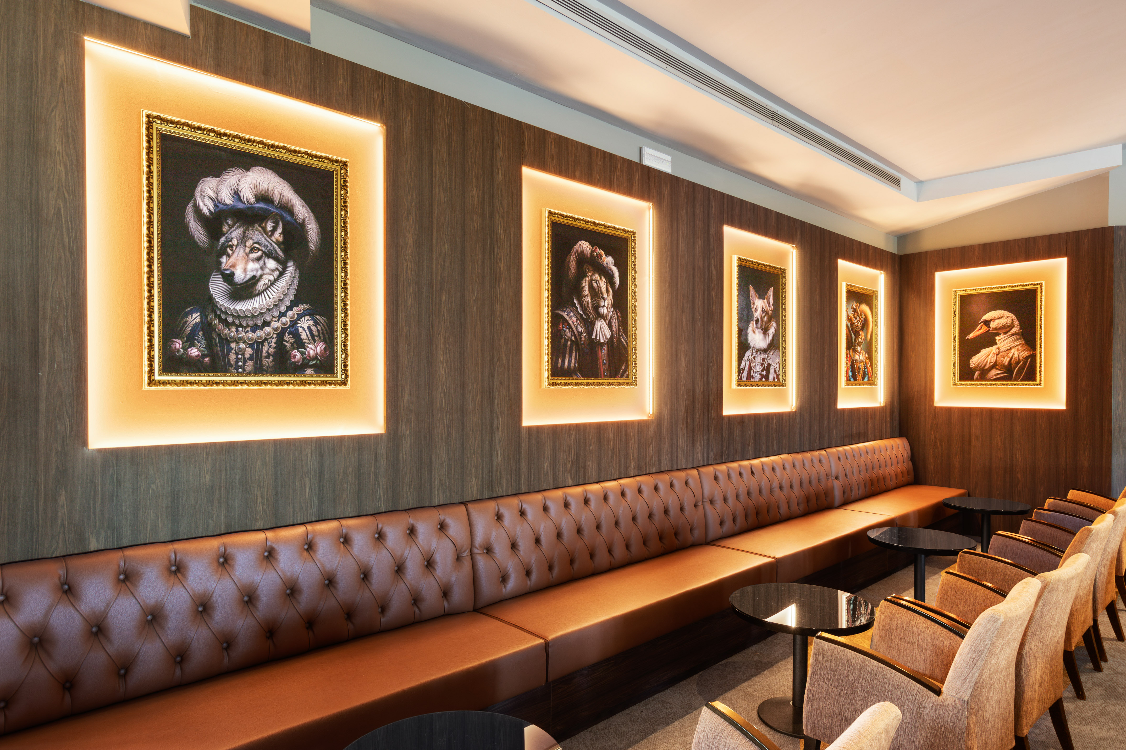 Lounge interior with long brown leather booth, wood walls, backlit animal portraits.