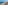 Sandy beach with white umbrellas, turquoise ocean, and a coastal boardwalk.
