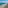 Resort beach with white umbrellas, clear blue ocean, and coastal dunes.