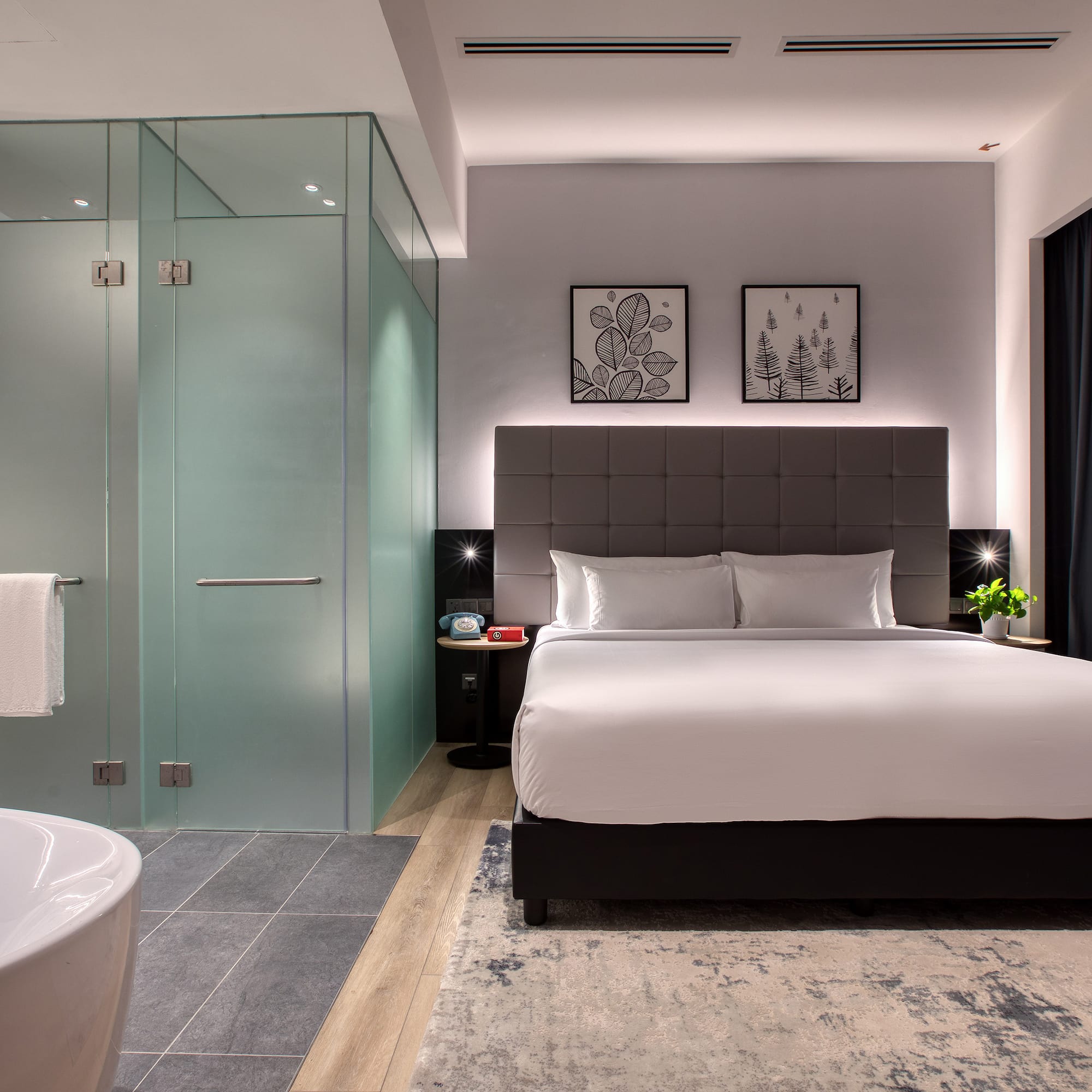 a bedroom with a glass shower and a bed