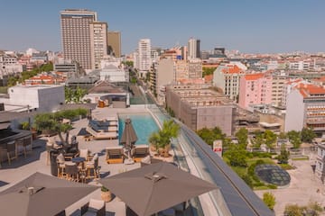 a rooftop view of a city with a pool and umbrellas