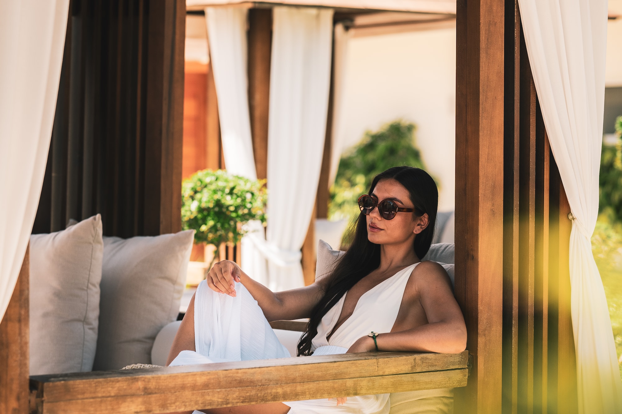 a woman in a white dress sitting on a bench