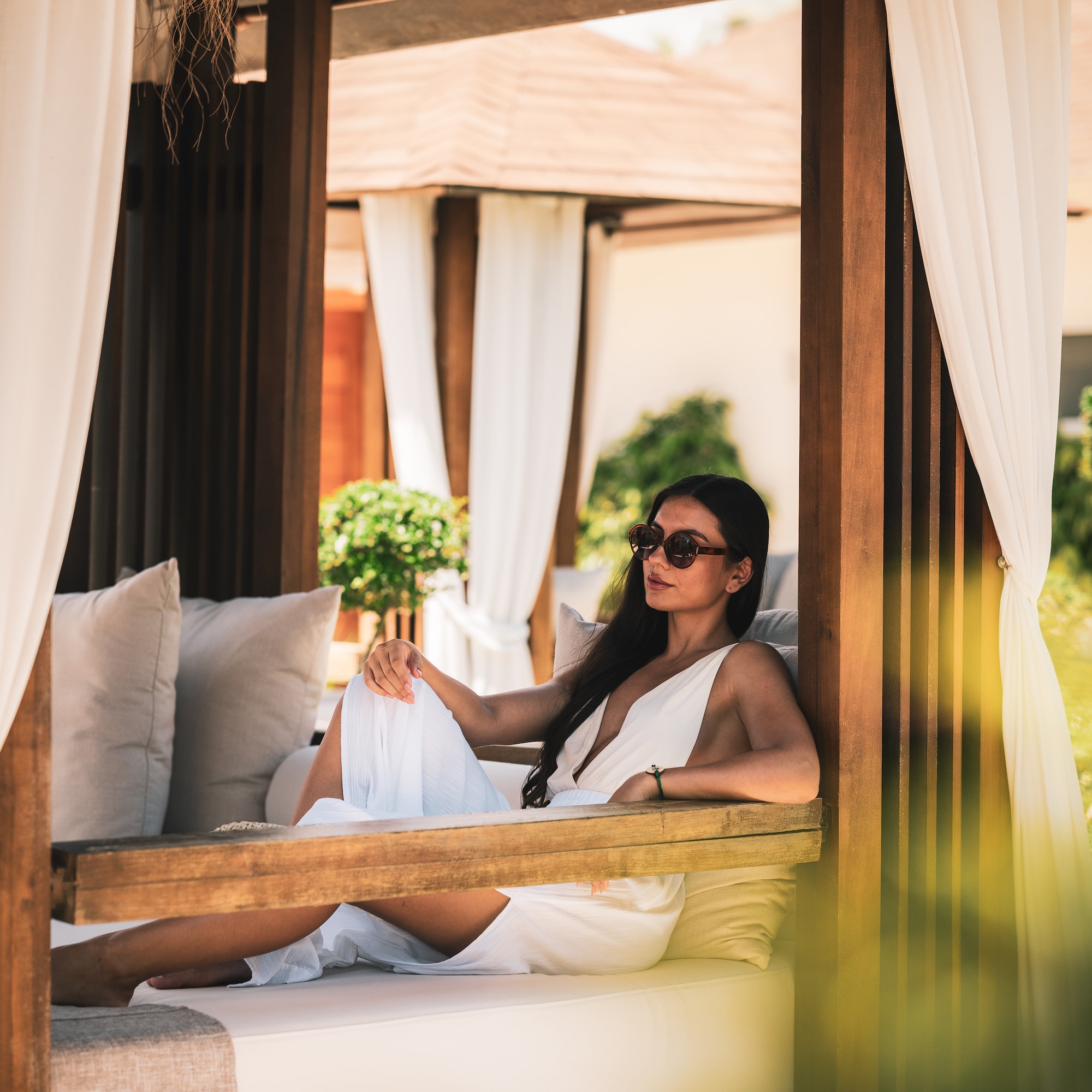 a woman in a white dress sitting on a bench